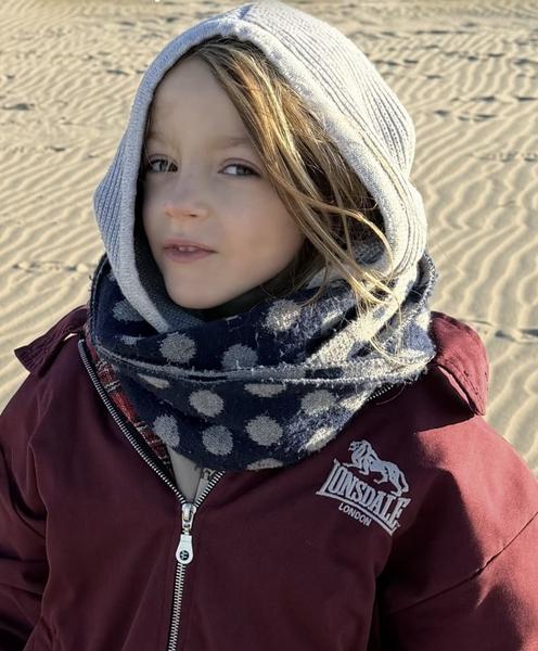 A close-up portrait features a child wearing a grey hoodie, a blue polka-dot scarf, and a maroon jacket, looking directly at the camera